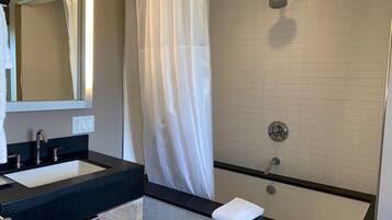 Un baño moderno con lavamanos doble, ducha y bañera.