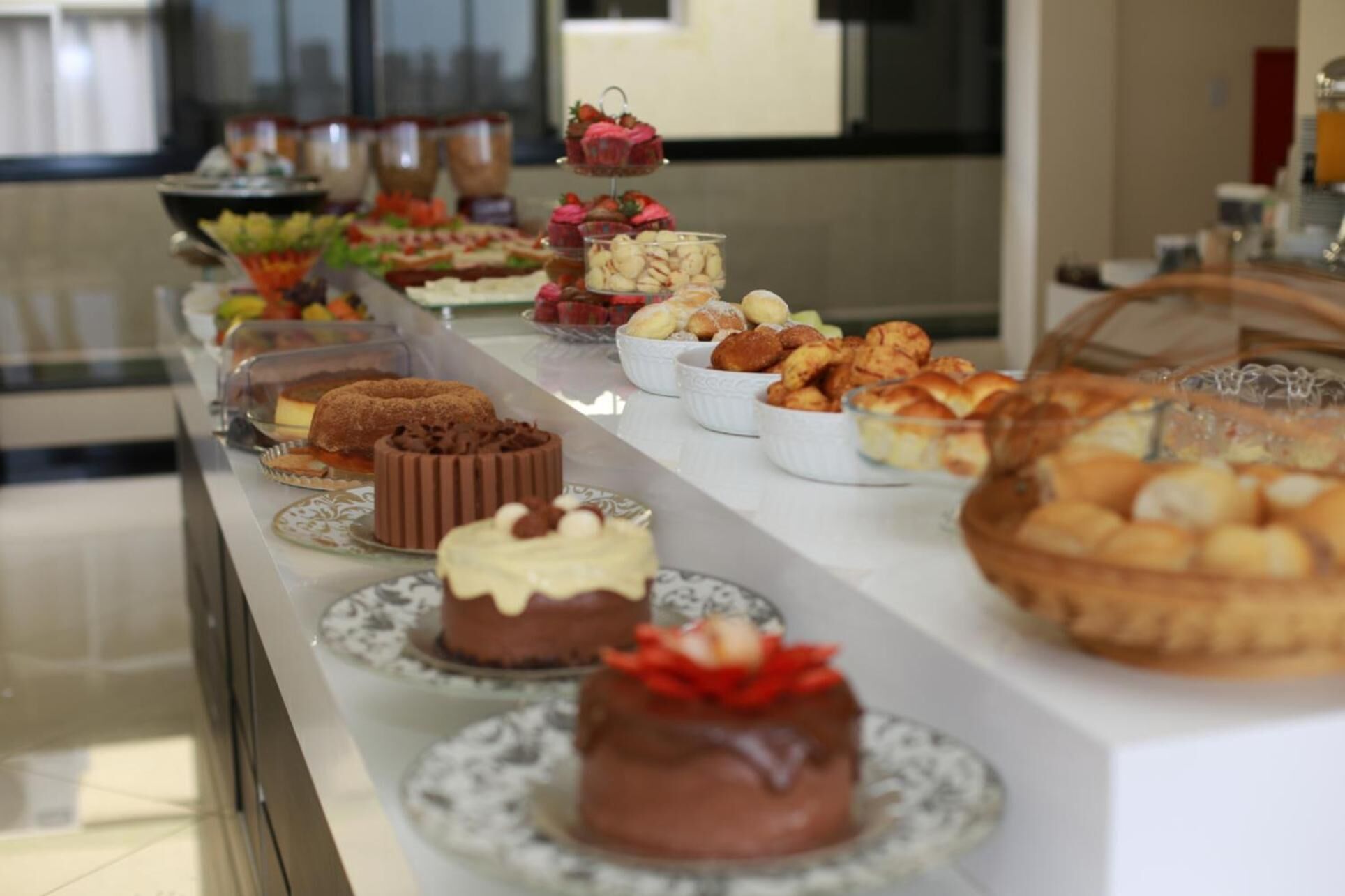 Un bufé con diversos postres y pasteles expuestos en una barra.