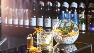 Un bar con una variedad de botellas, un vaso con hielo y un adorno.