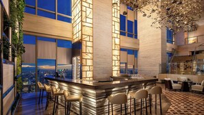 Una cucina moderna con angolo bar, ampie finestre e vista sulla città.