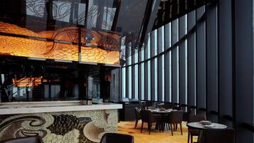 A modern interior with a dining area, a patterned wall, and large windows.