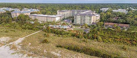 Un resort con varias edificaciones, una piscina y una zona de playa.