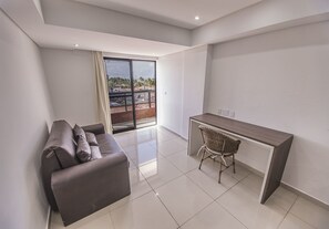 Estúdio superluxo, 1 quarto, varanda coberta, ao lado da praia | Área de estar | TV de tela plana 32 polegadas com canais a cabo, TV