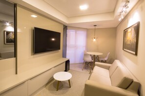 Suíte estúdio superluxo, 1 quarto, varanda coberta | Área de estar | TV de tela plana 32 polegadas com canais a cabo, TV