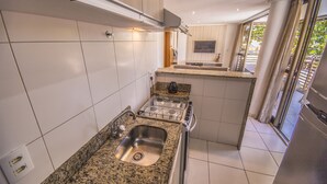 Eine moderne Küche mit Granit-Arbeitsplatten, Edelstahlgeräten und einem großen Fenster, das für natürliches Licht sorgt.