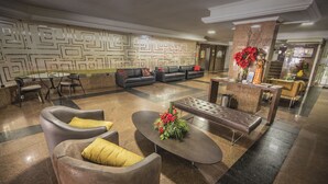 Un vestíbulo con zona de estar, mostrador de recepción y una pared decorativa.
