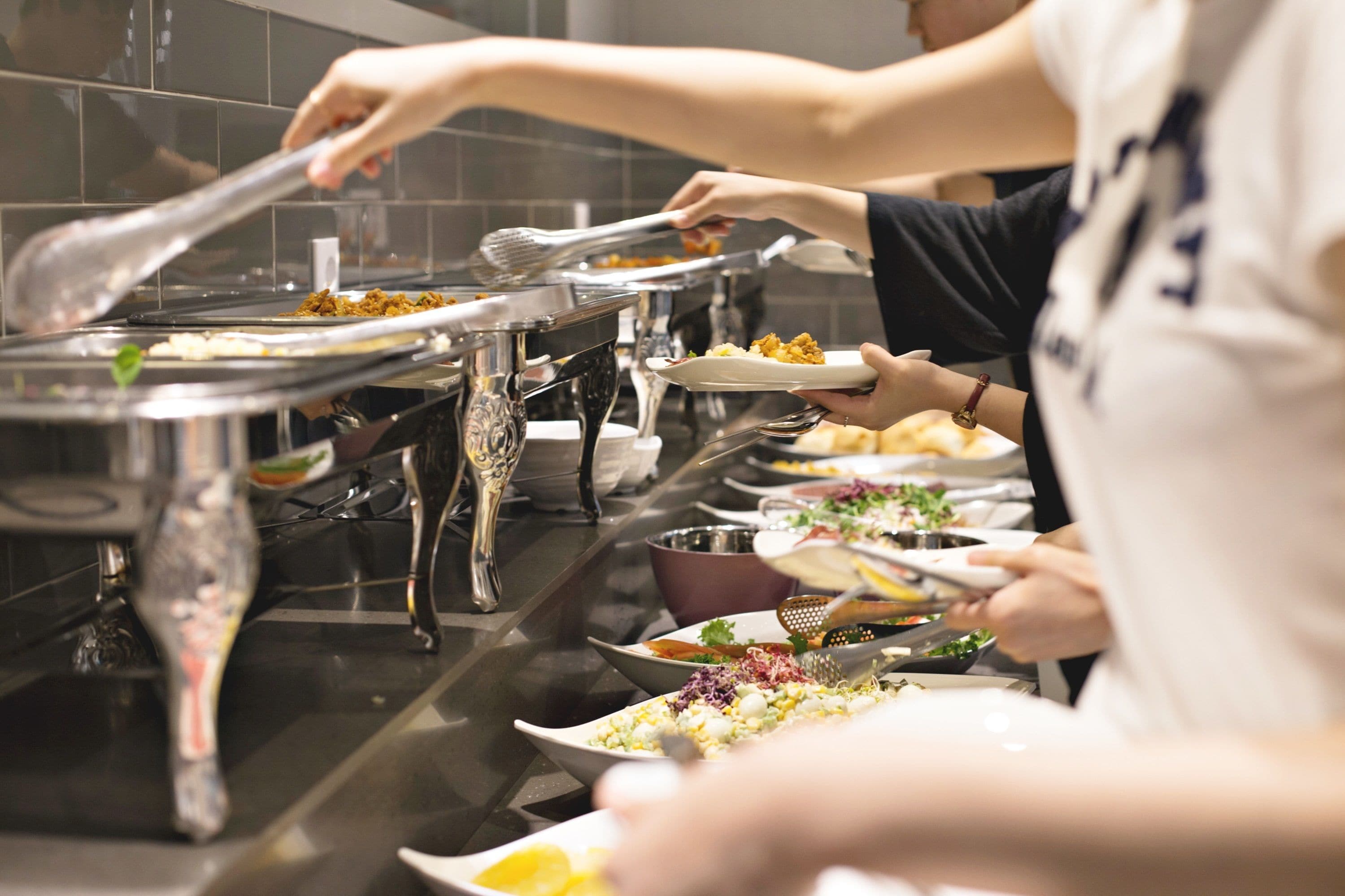 A buffet setup with multiple serving dishes and utensils.