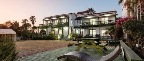 Un edificio de varios pisos con balcón y zona de estar al aire libre.