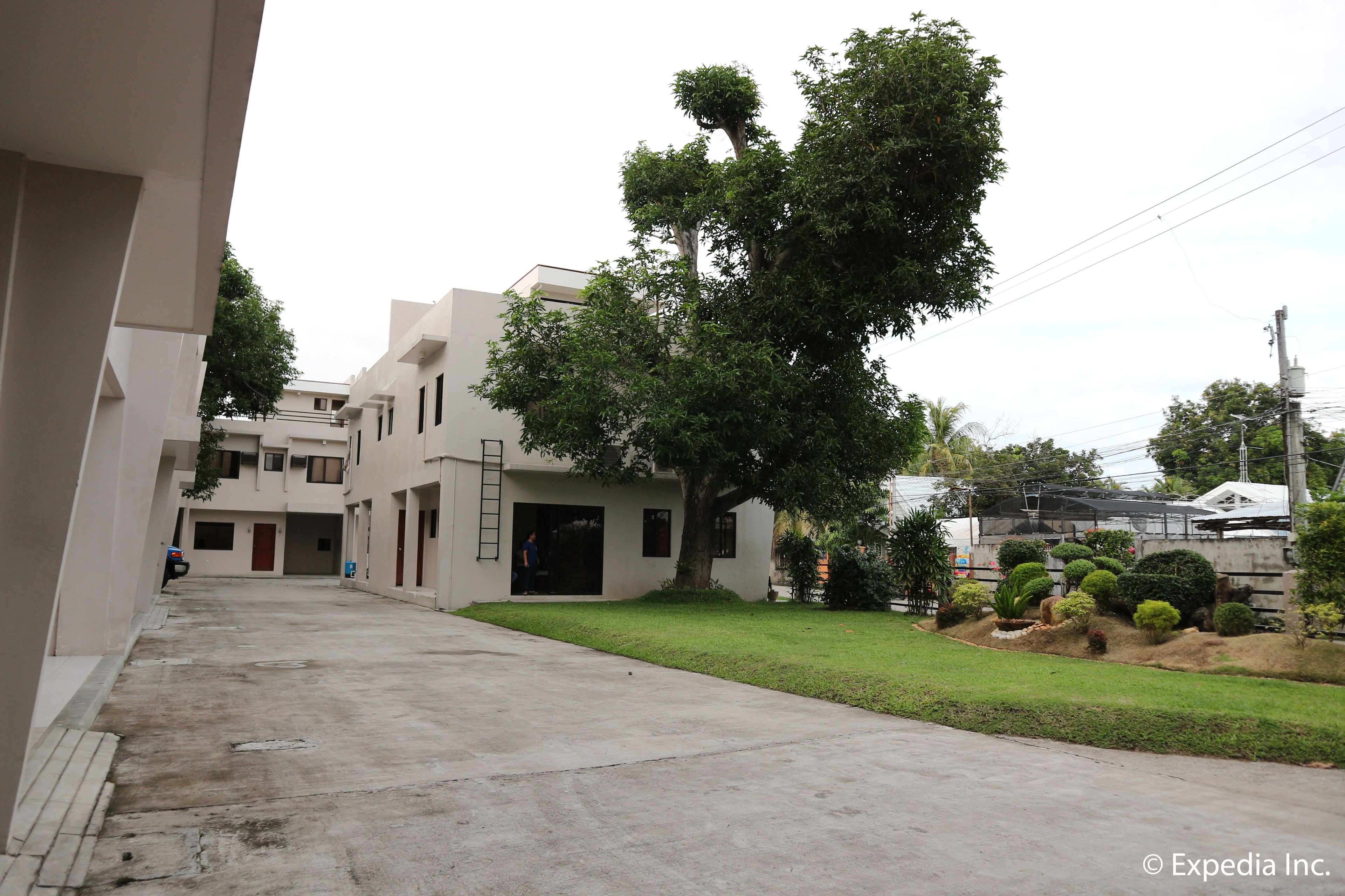 Uma área residencial com edifícios modernos, uma entrada pavimentada e um gramado bem cuidado.