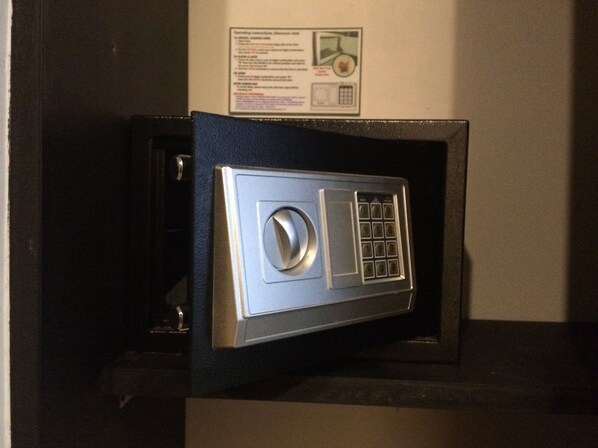 Una caja fuerte anclada a la pared, con un dial de combinación y un teclado.