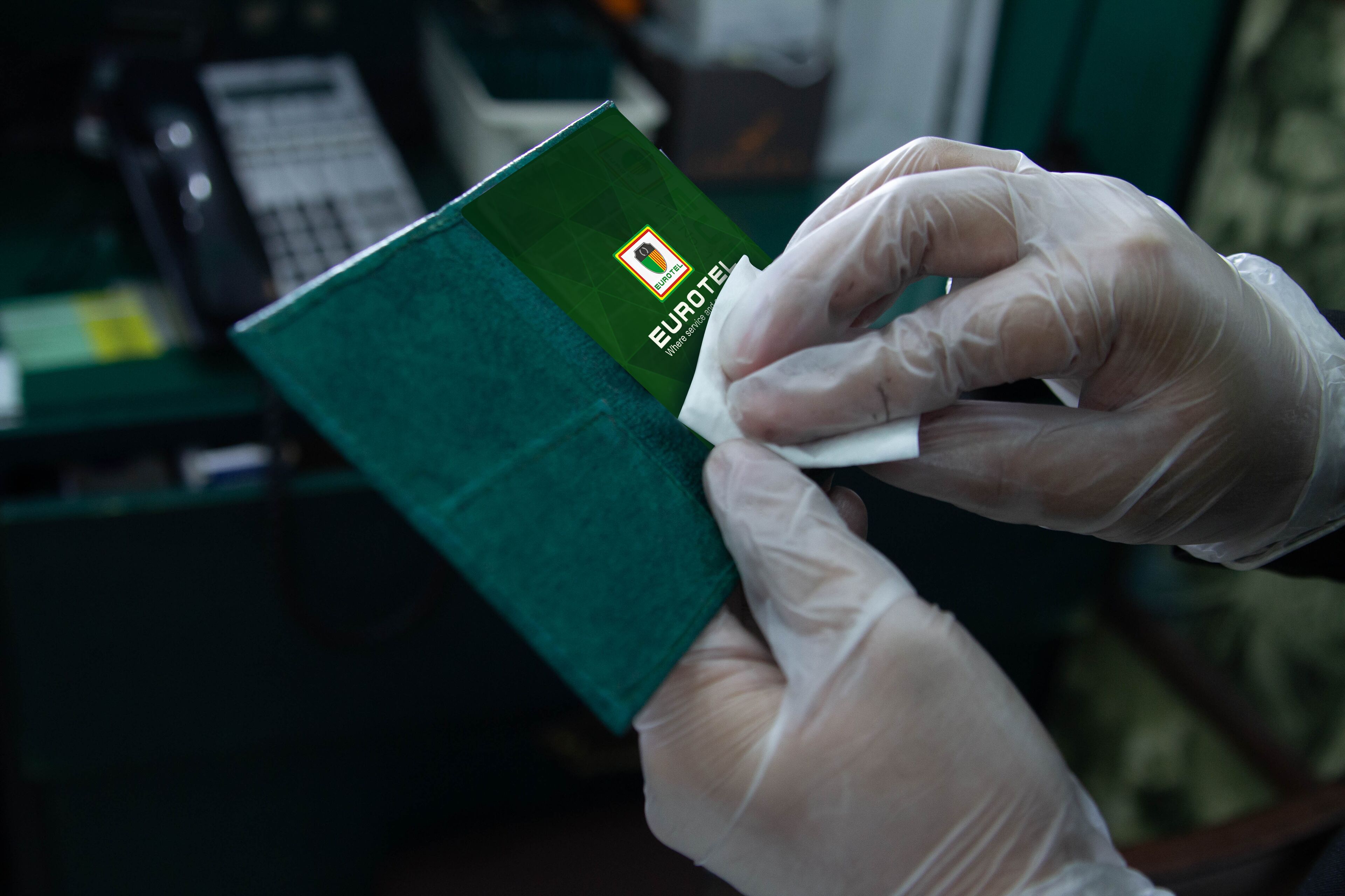 Una persona con guantes manipula un objeto verde con un logotipo.