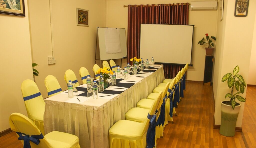 A conference room with a long table, yellow chairs, and a whiteboard.