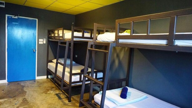 Beliches em um quarto com porta azul e teto amarelo.