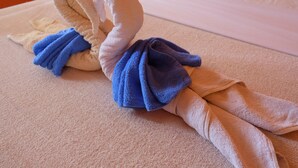 Duas toalhas dobradas em forma de cisnes sobre uma cama.