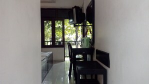 A narrow hallway with a window, a radiator, and a table with chairs. - Sarathchandra Tourist Guest House (Embilipitiya)
