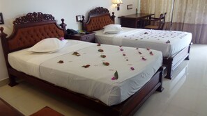 Two double beds with white linens and decorative floral arrangements. - Sarathchandra Tourist Guest House (Embilipitiya)