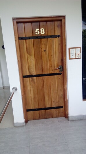 A wooden door with the number 58, a metal handle, and a wall-mounted electrical outlet. - Sarathchandra Tourist Guest House (Embilipitiya)