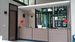 A reception desk with a clock, a red lamp, and a sign. - Woodroof Residence Rangsit (Pathum Thani)