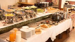 A buffet setup with various food items and serving utensils.