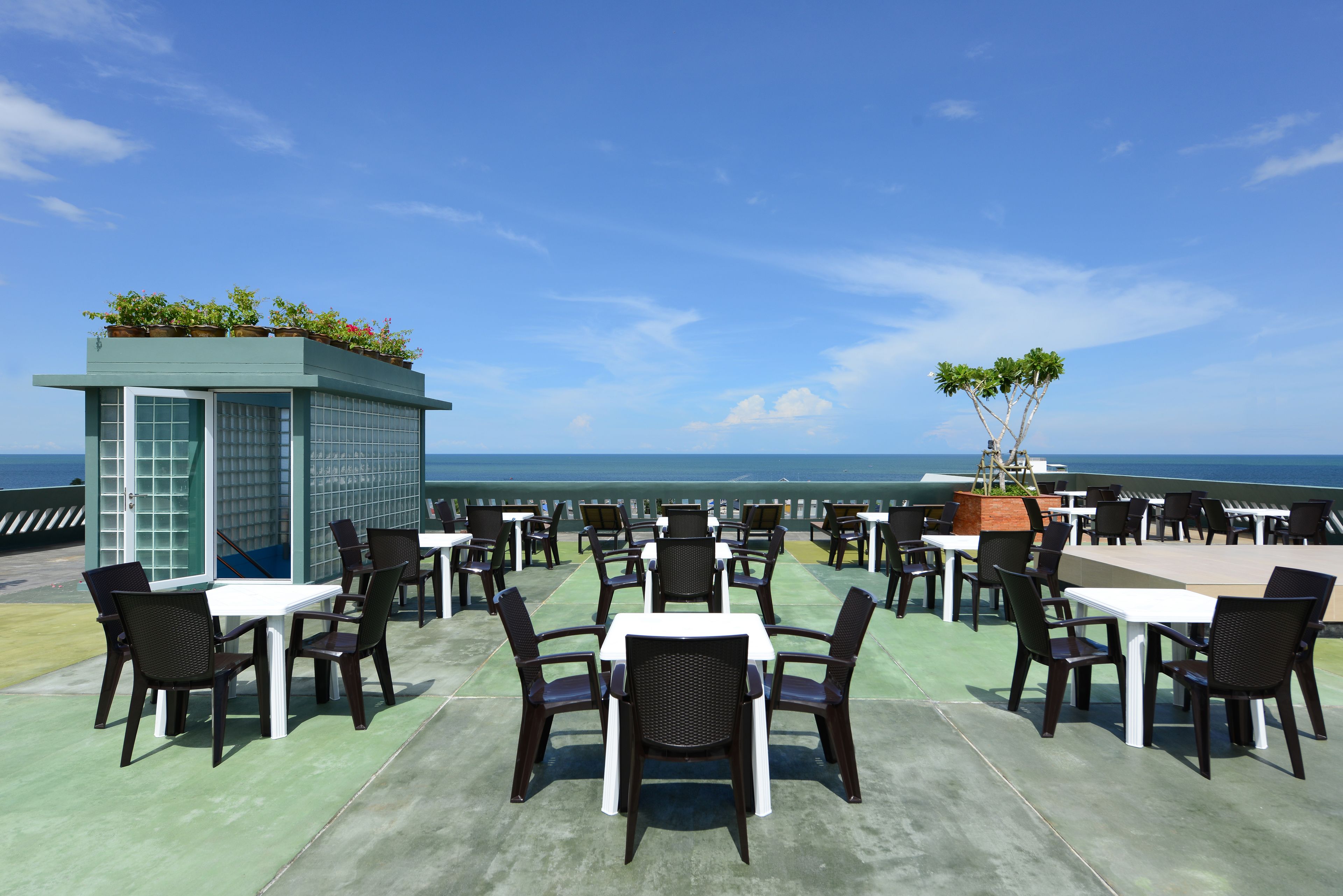 A rooftop terrace with outdoor seating and a view of the ocean.