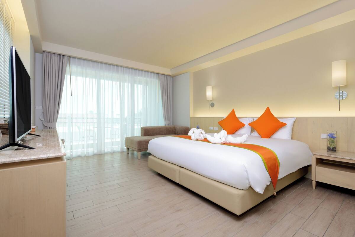 Deluxe Corner King Room | Minibar, in-room safe, desk, blackout drapes