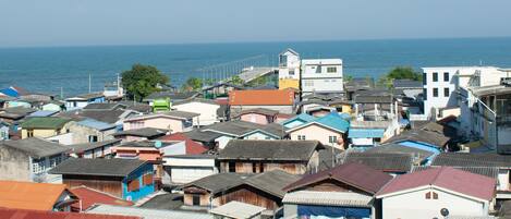 A coastal residential area with various buildings, some with visible balconies and a clear view of the sea.
