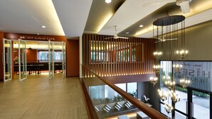Un intérieur moderne avec un escalier, un coin repas et une vue sur l’extérieur.