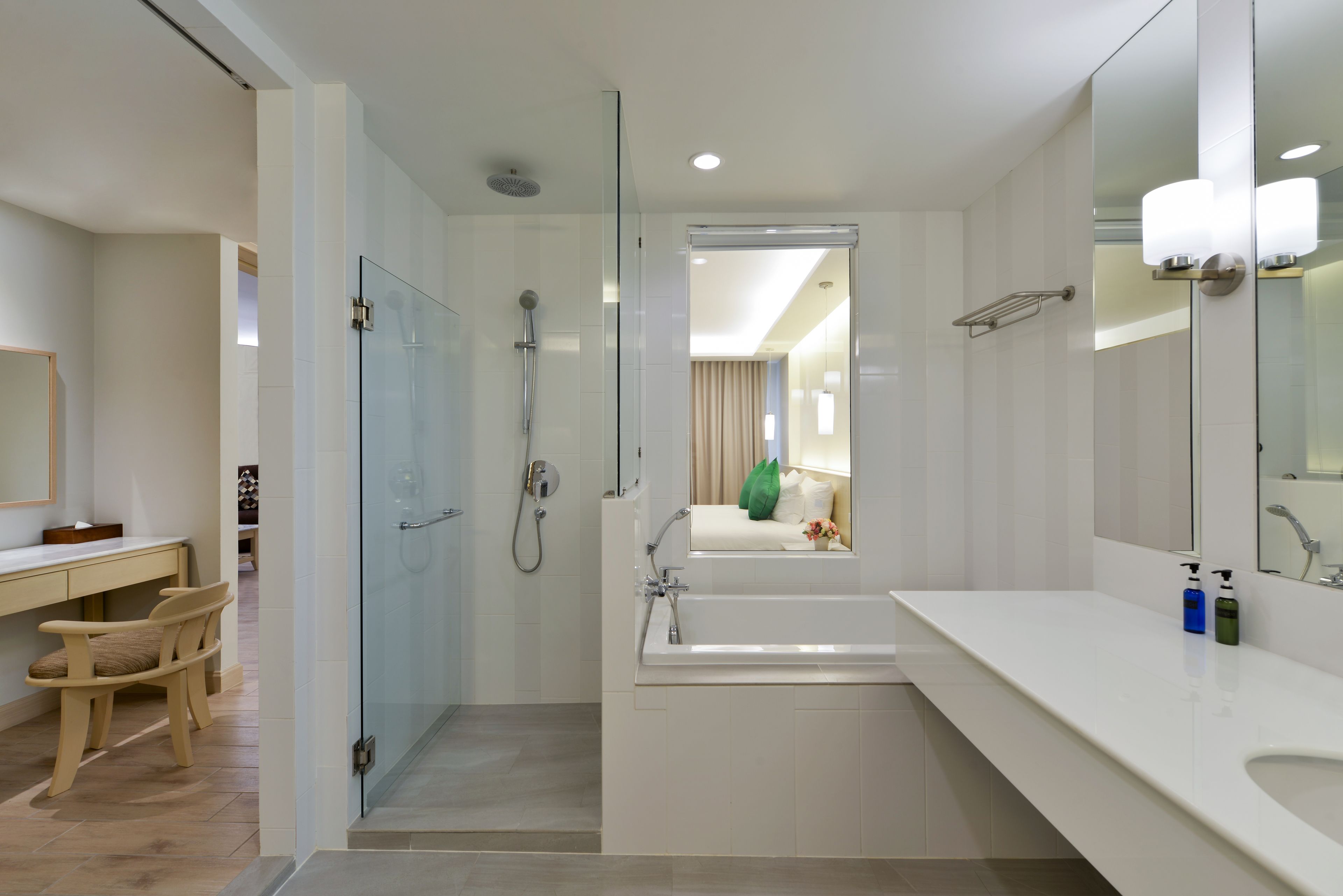 Ein modernes Badezimmer mit einer gläsernen Duschkabine, einer großzügigen Badewanne und einem Waschtisch mit Spiegel.