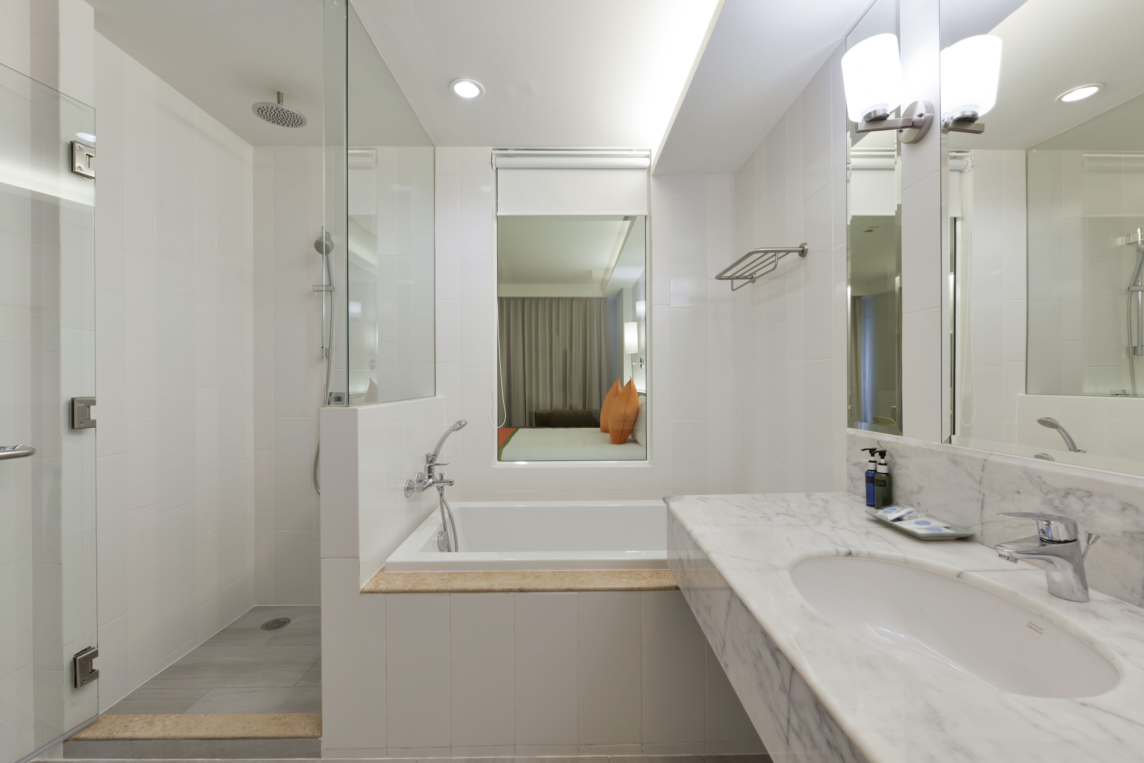 Un bagno moderno con doccia vetrata, lavandino capiente e specchio.