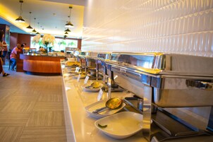 Una barra de buffet con diversos platos y utensilios.