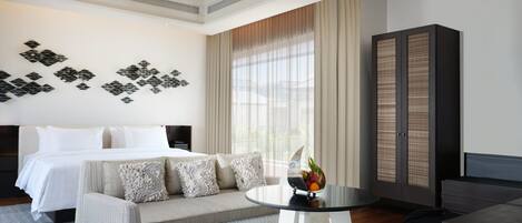 Una habitación de hotel moderna con cama, sofá y una mesa redonda con frutero.