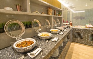 A buffet setup with various dishes and utensils.