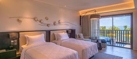 A hotel room with two beds, a small table, and a balcony with a view.