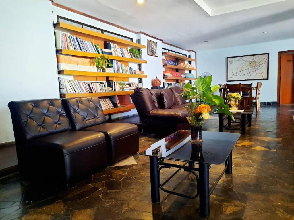 A living room with a leather sofa, a coffee table, and bookshelves filled with books.
