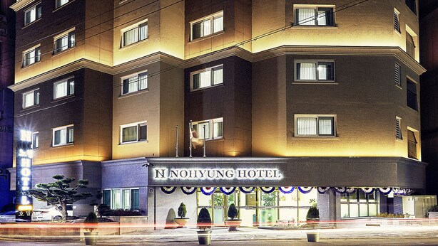 A multi-story hotel with a zigzag facade, illuminated windows, and a sign reading "Nohyung Hotel". - Nohyung Hotel (Jeju City)