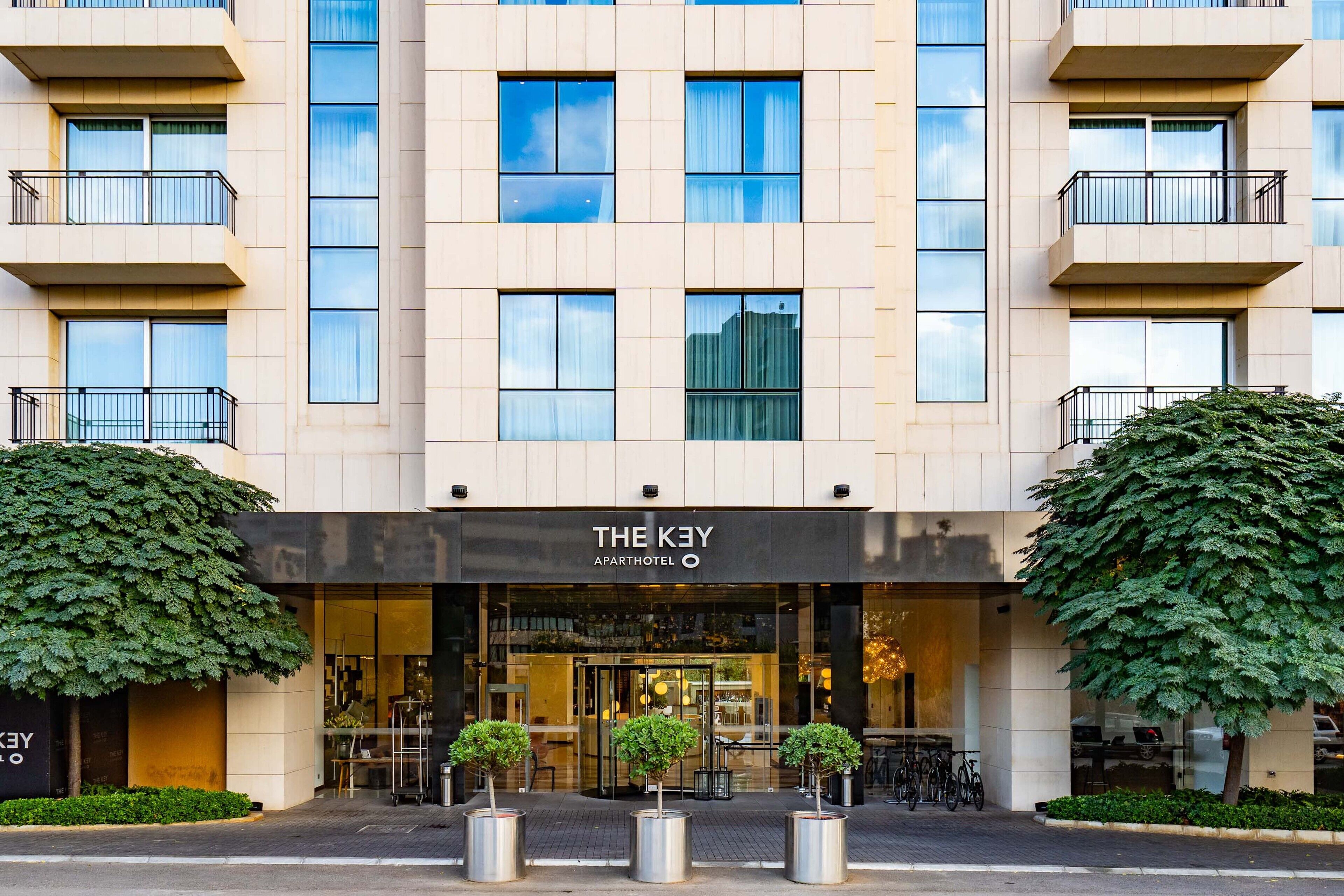 Un edificio moderno con un letrero que dice "THE KEY APARTMENT HOTEL".