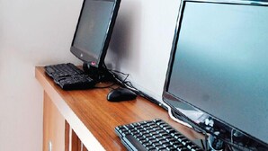 A desk with two monitors, a keyboard, and a mouse. - Place2Stay - RH (Kuching)