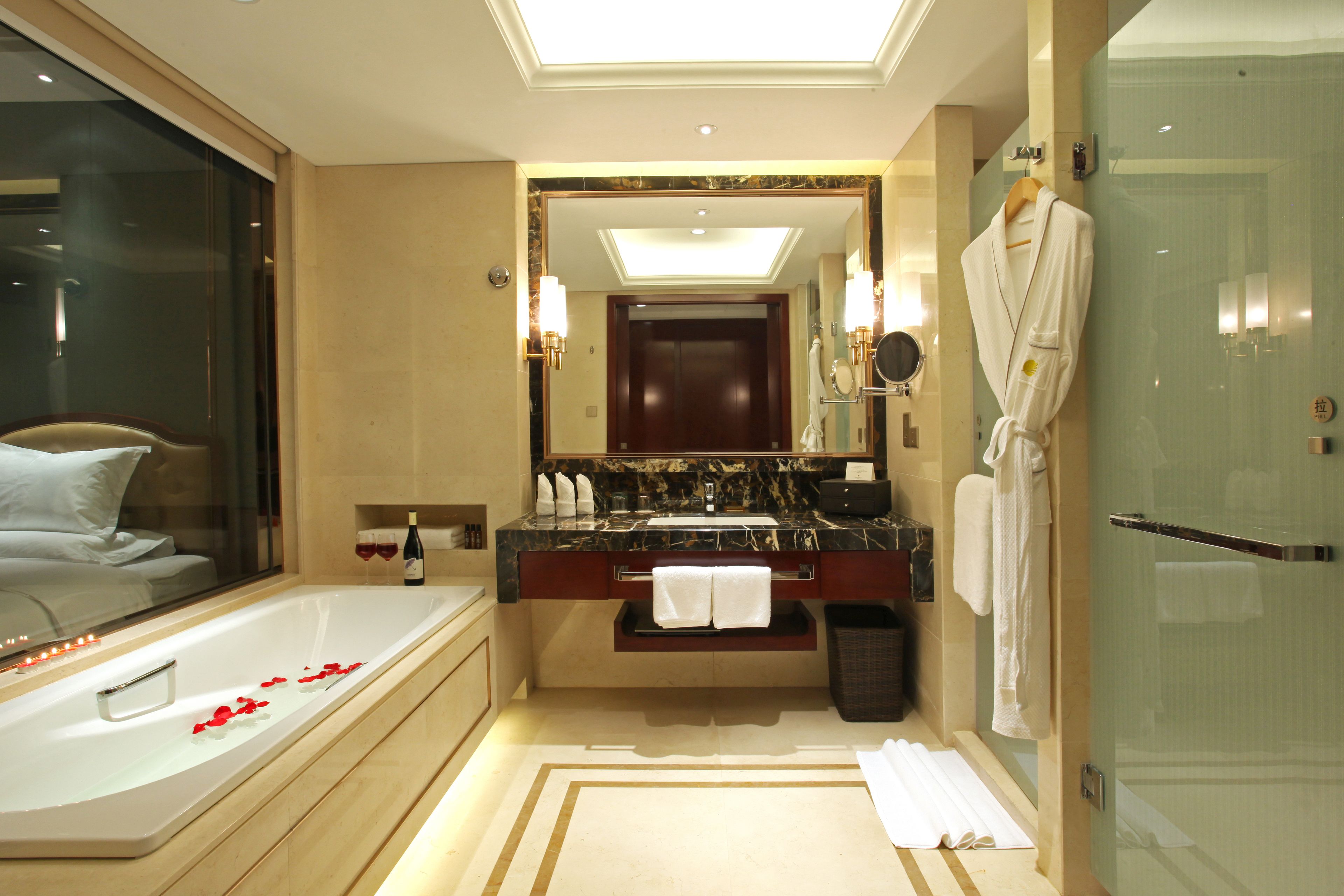 A modern bathroom with a large bathtub, a glass shower enclosure, and a vanity with a marble countertop.