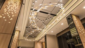 Un intérieur moderne avec un plafond au design original, agrémenté de luminaires suspendus et de motifs géométriques sur les murs.