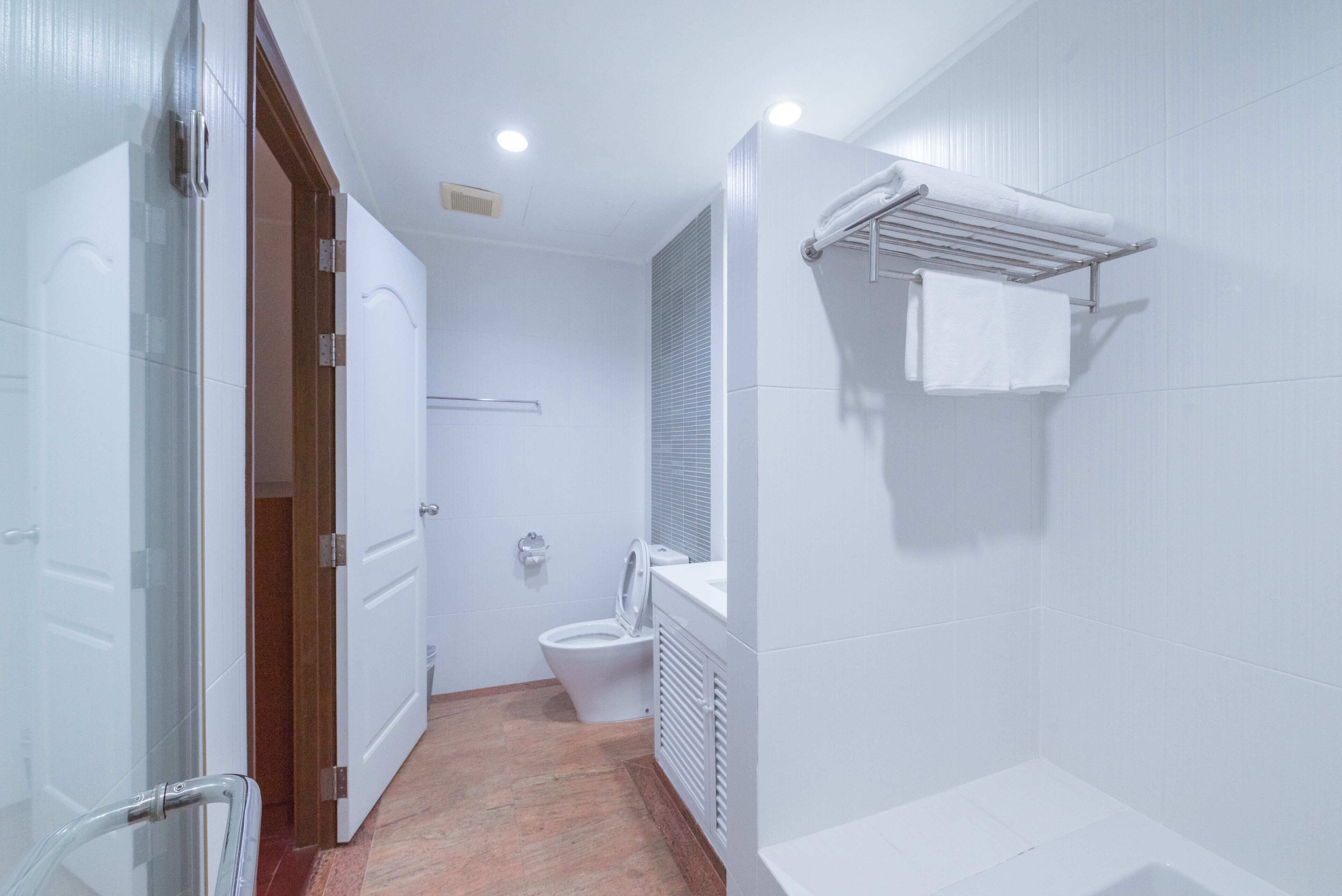 Ein Badezimmer mit Toilette, Duschbereich und Handtuchhalter.