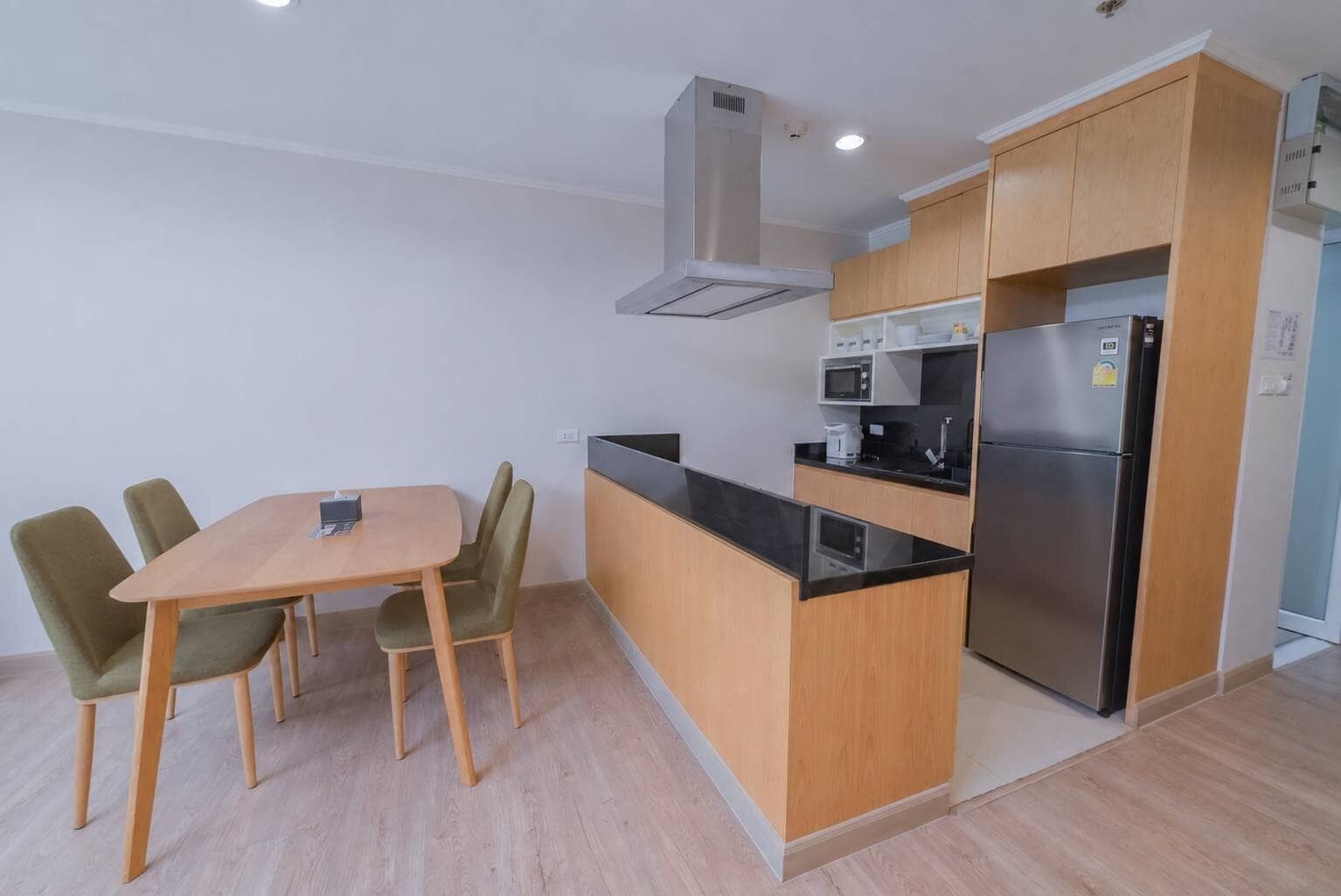 A compact kitchen with a dining area, featuring a central island, built-in appliances, and a modern design.