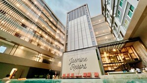Un bâtiment moderne avec une grande enseigne indiquant « Jasmine Resort ».