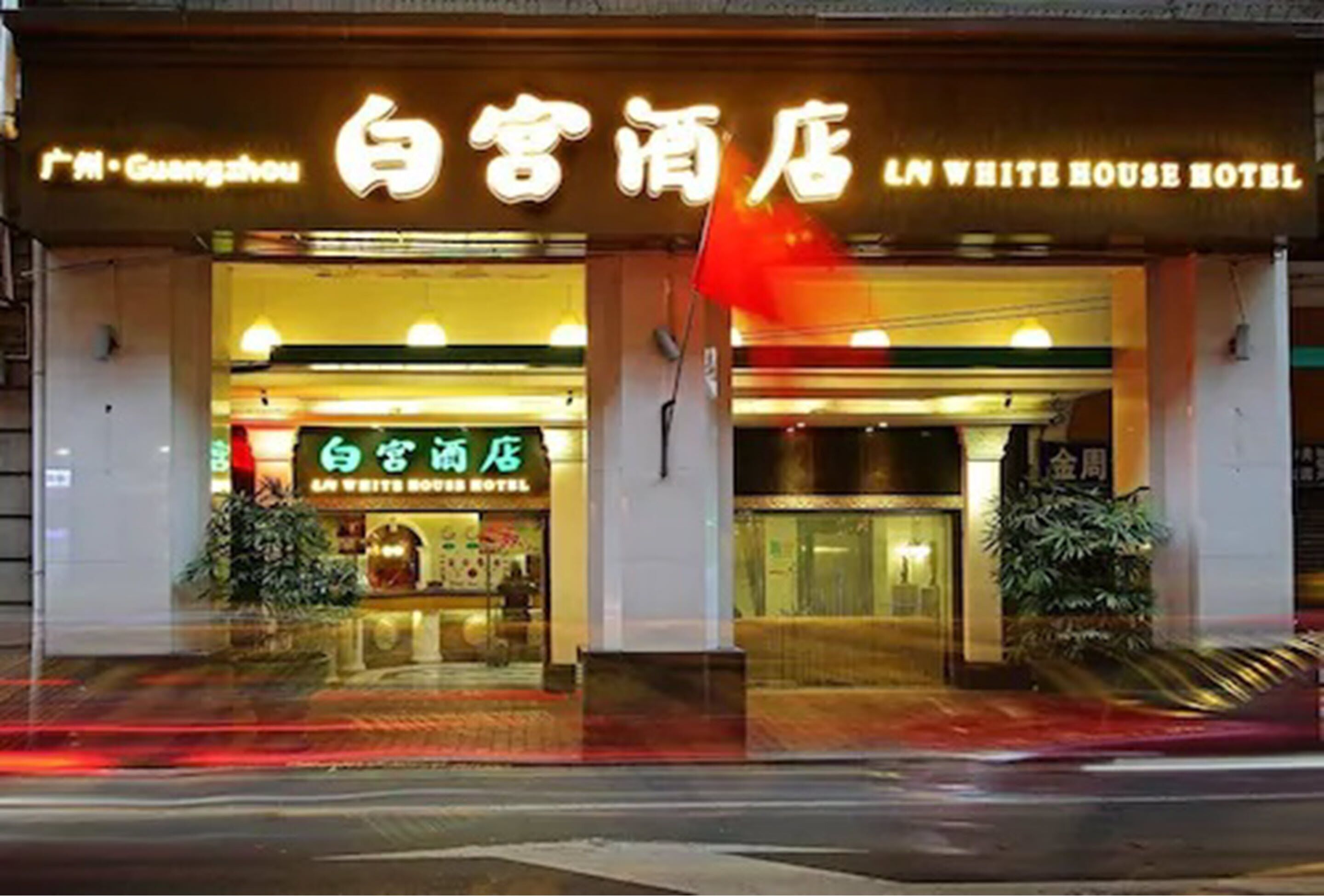 A hotel entrance with signage in multiple languages, including English and Chinese.