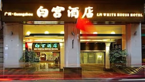 Ein Hotel Eingang mit Beschilderung in verschiedenen Sprachen, darunter Englisch und Chinesisch.