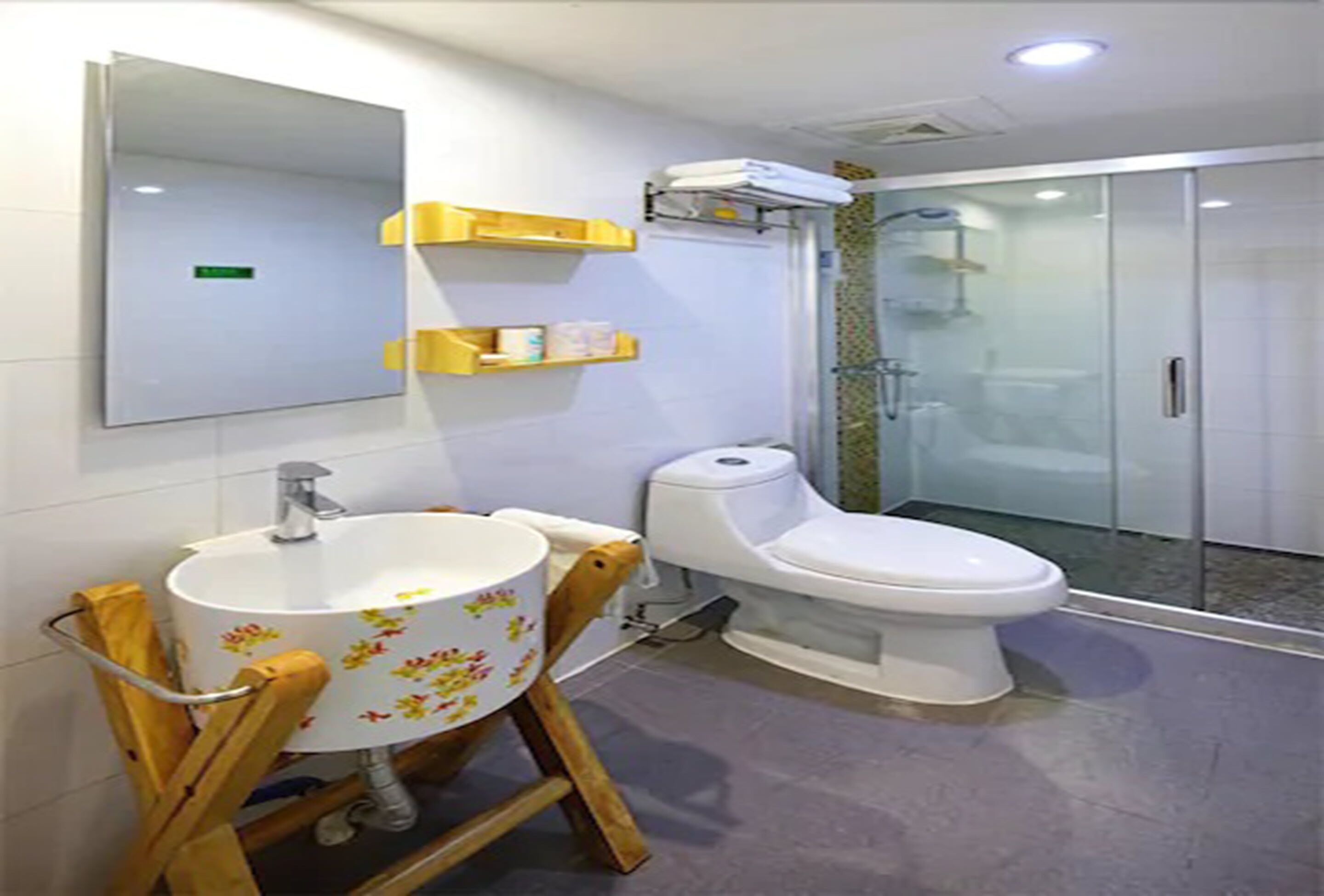 A bathroom with a sink, toilet, and glass shower enclosure.