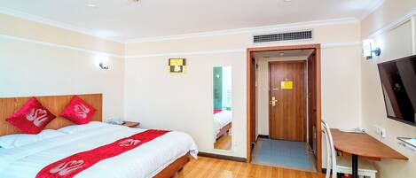 Una habitación de hotel con cama, escritorio, silla y televisión.