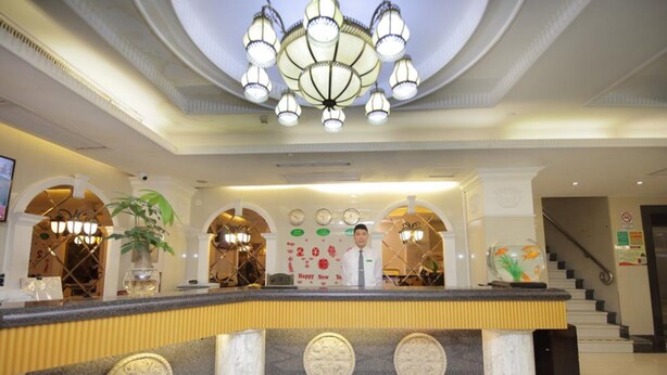 Eine Hotelrezeption mit Marmorzauber, einem Kronleuchter und einer Treppe im Hintergrund.