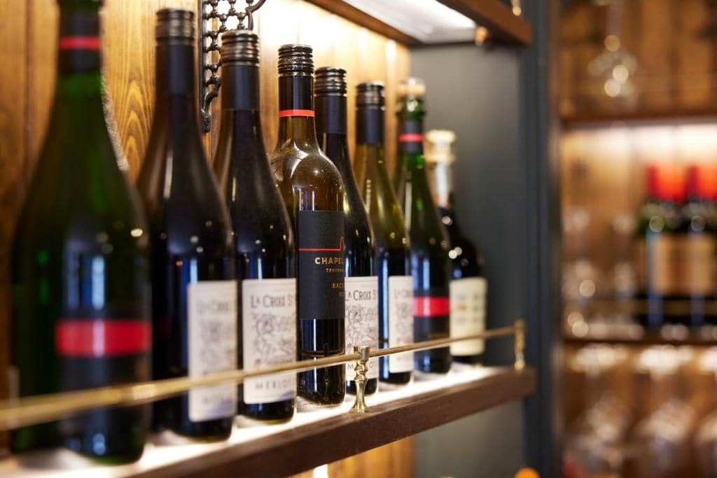 A selection of wine bottles on a shelf.