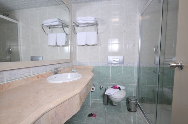 A bathroom with a sink, mirror, towel rack, toilet, and shower. - Hotel My Dream (Marmaris)