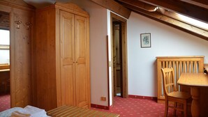 Una habitación con muebles de madera, una cama, una mesa y una silla.